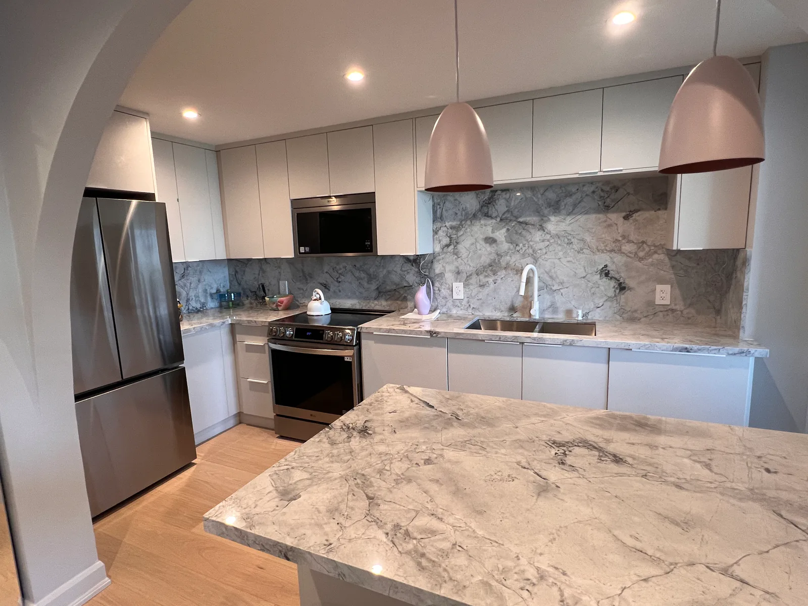 Finished kitchen with white cabinetry and marble-look surfaces at 3000 Bathurst