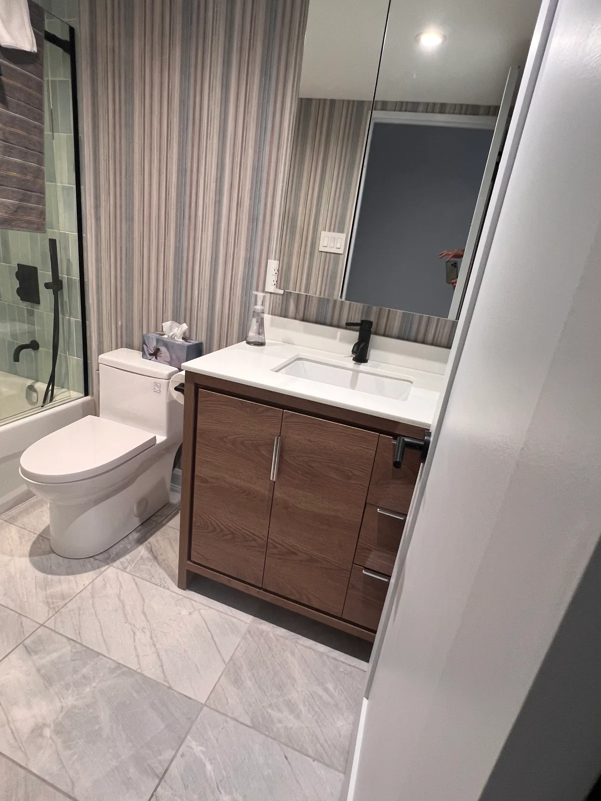 Completed bathroom vanity, mirror, and tiled shower at 3000 Bathurst
