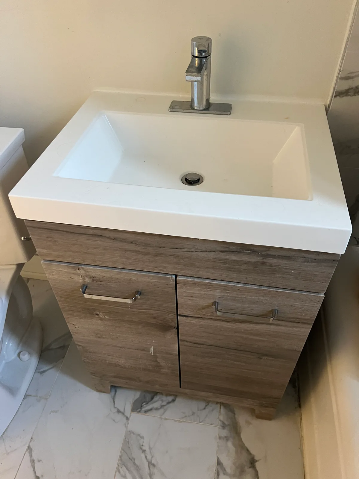 Bathroom vanity with wood-look drawers and white sink at 3000 Bathurst