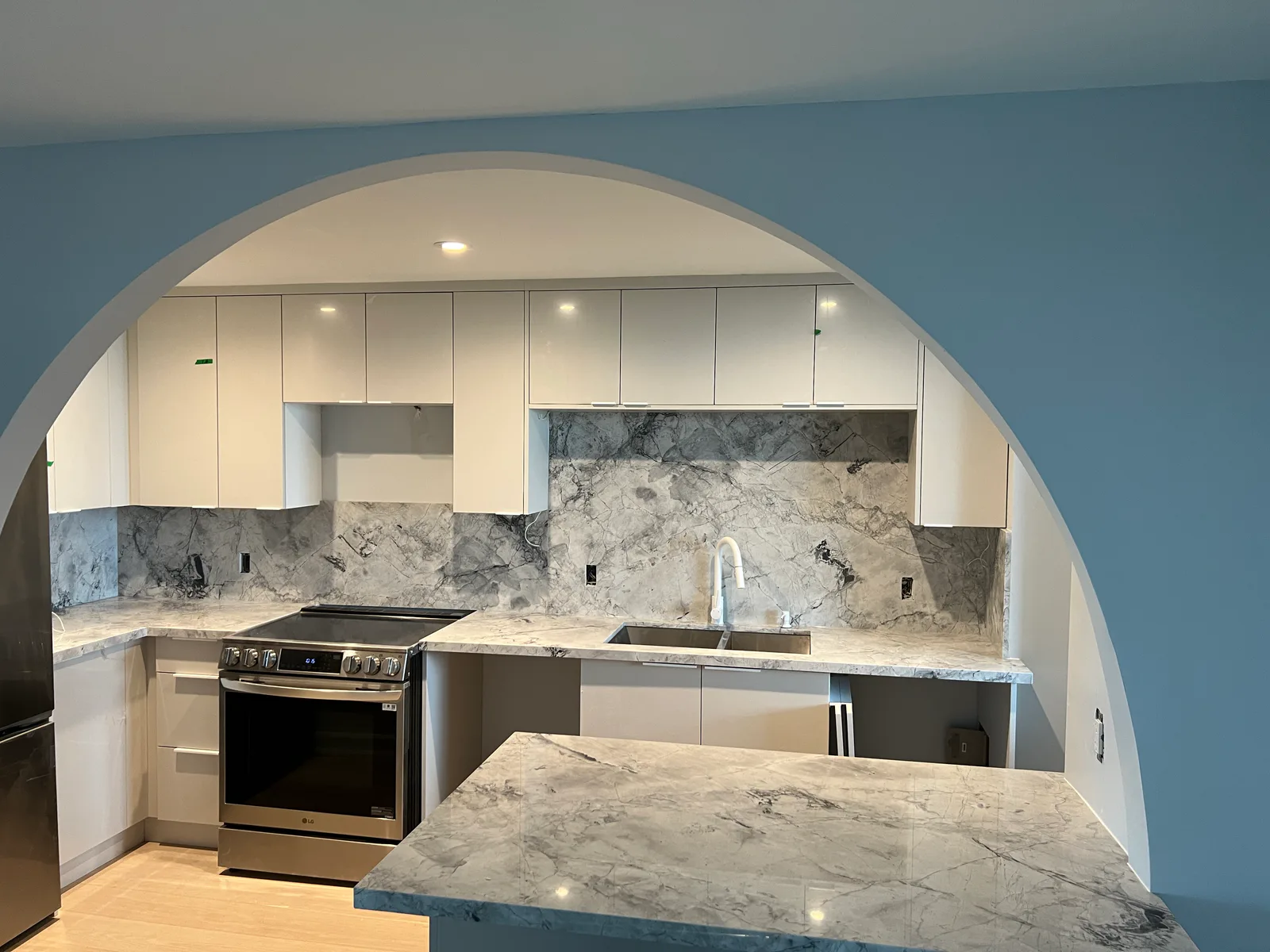 Finished kitchen with arched opening and marble-look counter at 3000 Bathurst