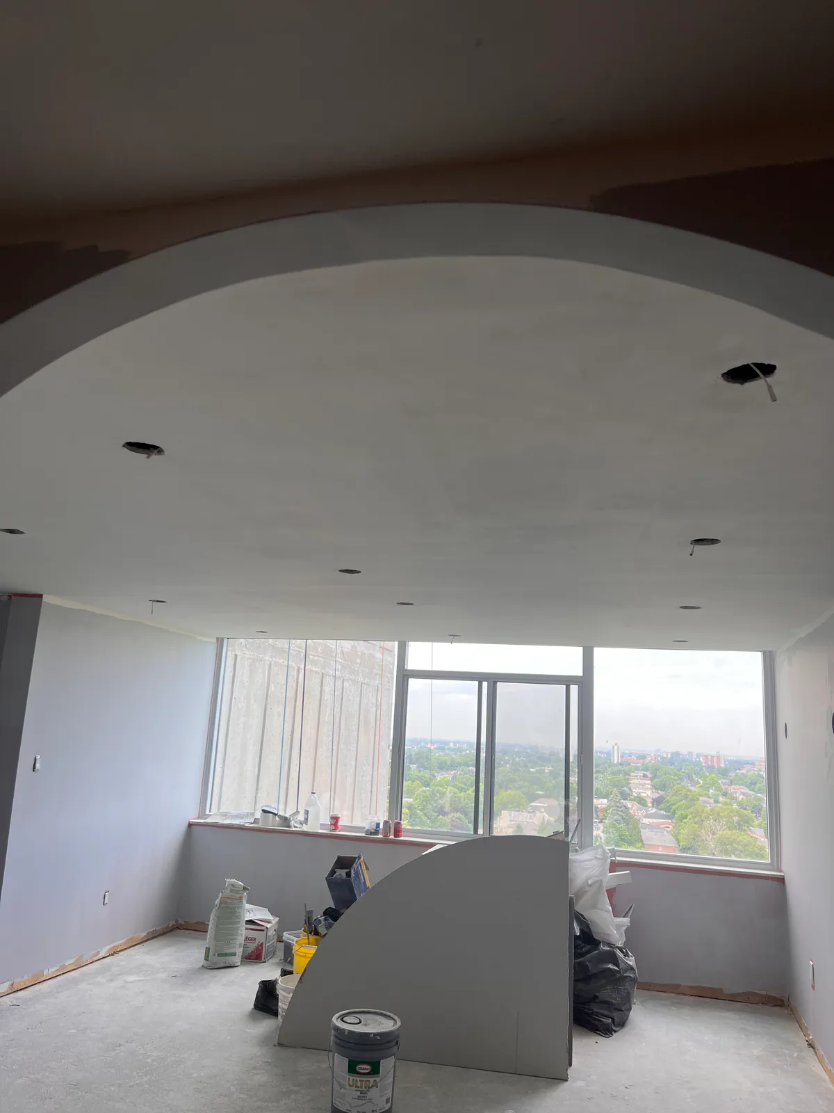 Large arched opening framing a window room during renovation at 3000 Bathurst