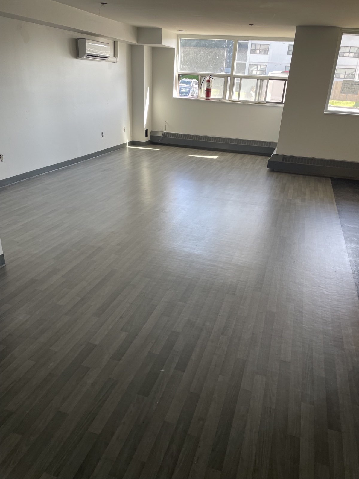 Common amenity room at finish stage with light resilient flooring, painted walls, and dark baseboards
