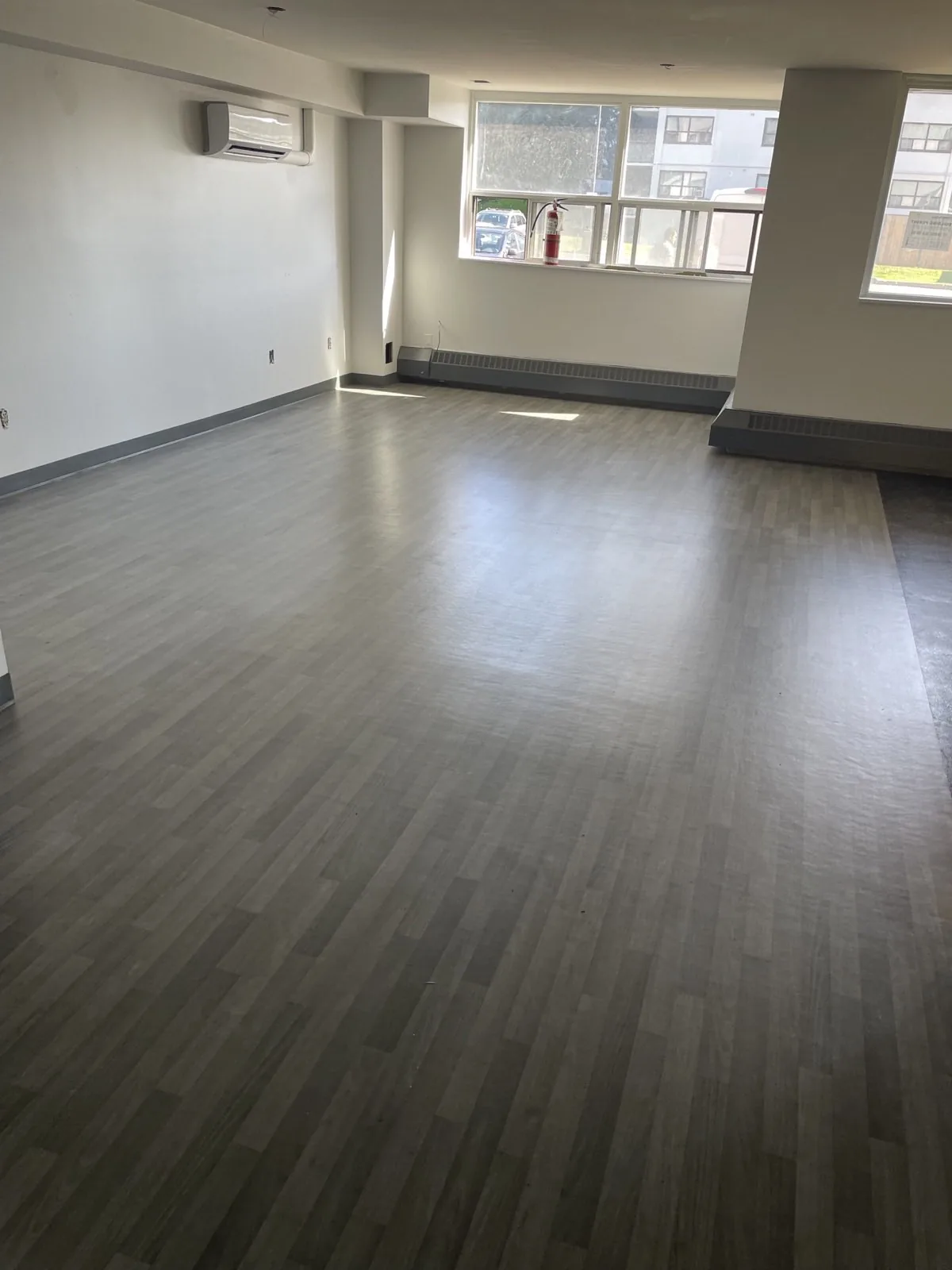 Common amenity room at finish stage with light resilient flooring, painted walls, and dark baseboards