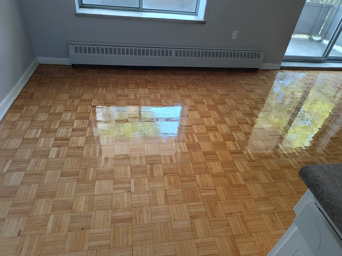 Wide view of repaired and refinished parquet below radiator on Dixon Road Etobicoke