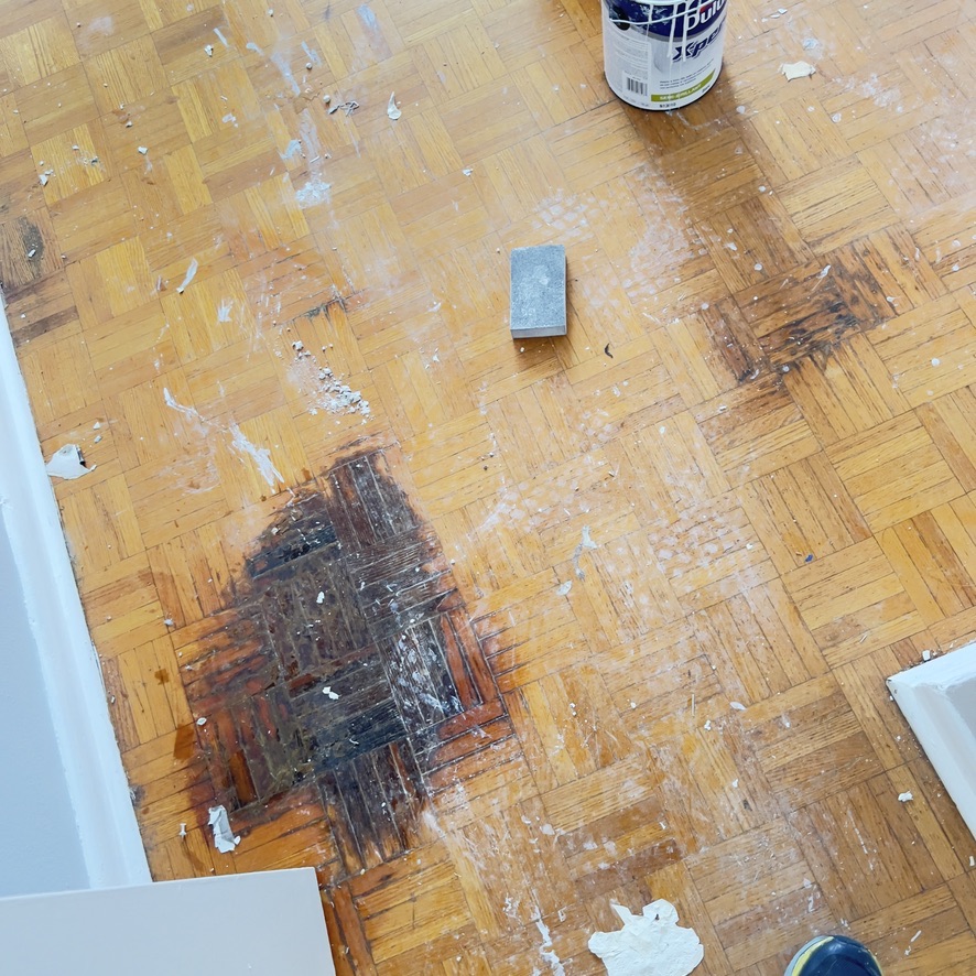 Dark damaged parquet blocks and surface debris before Etobicoke floor refinishing