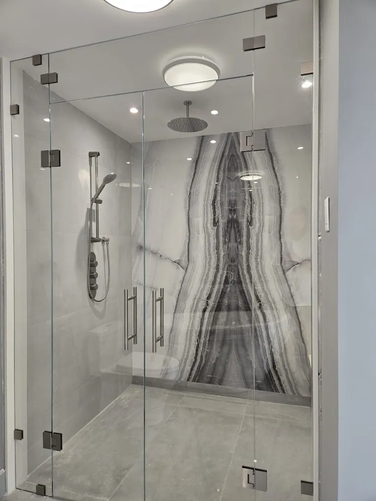 Walk-in shower with glass enclosure and feature wall tile