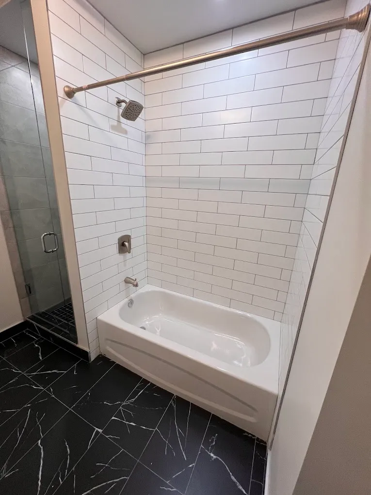 Finished bathroom with white subway tile and black floor tile