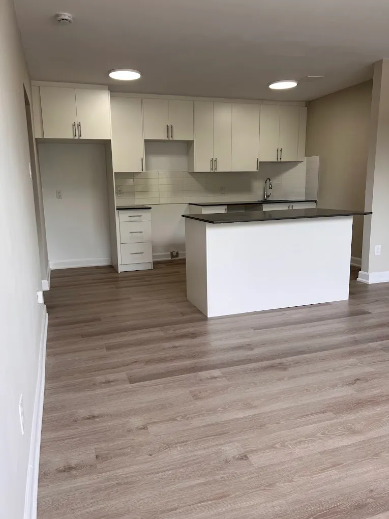 Finished white kitchen with dark countertop and new flooring