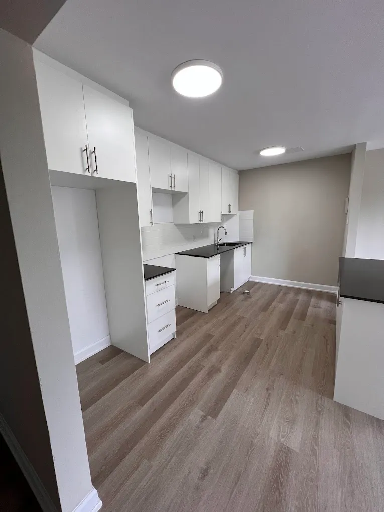 Completed white kitchen with new flooring and dark counter