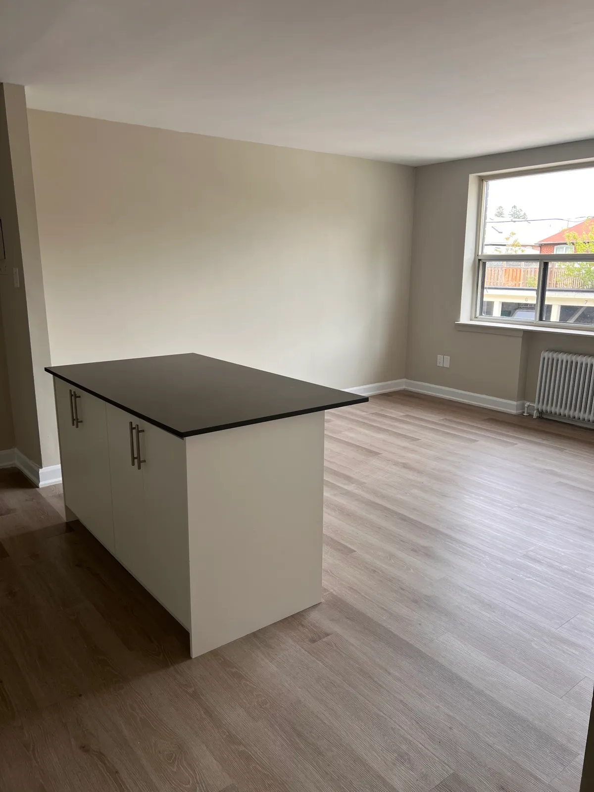 Finished kitchen island with new flooring and neutral wall finish