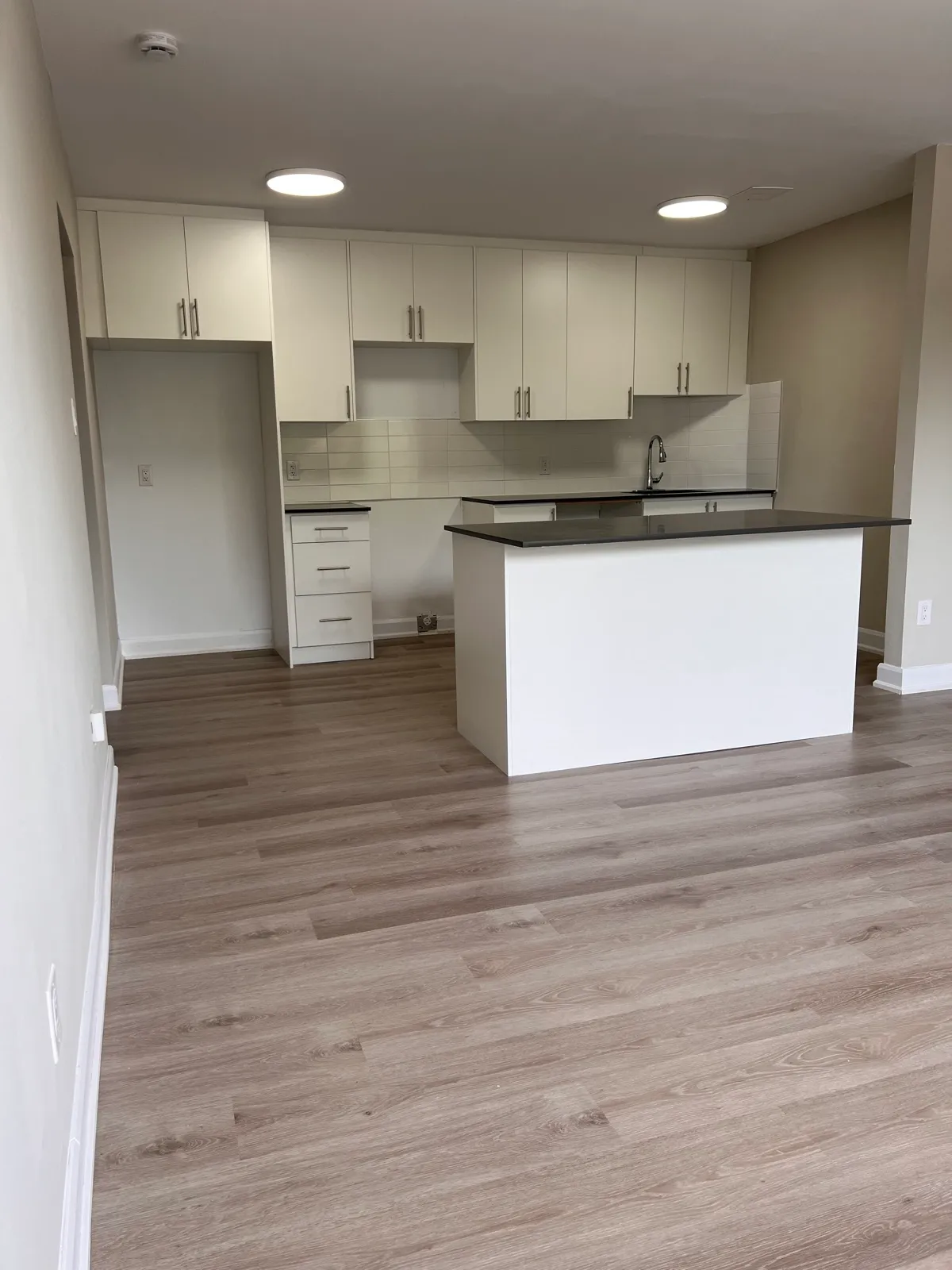 Finished white kitchen with island, subway tile, and new flooring