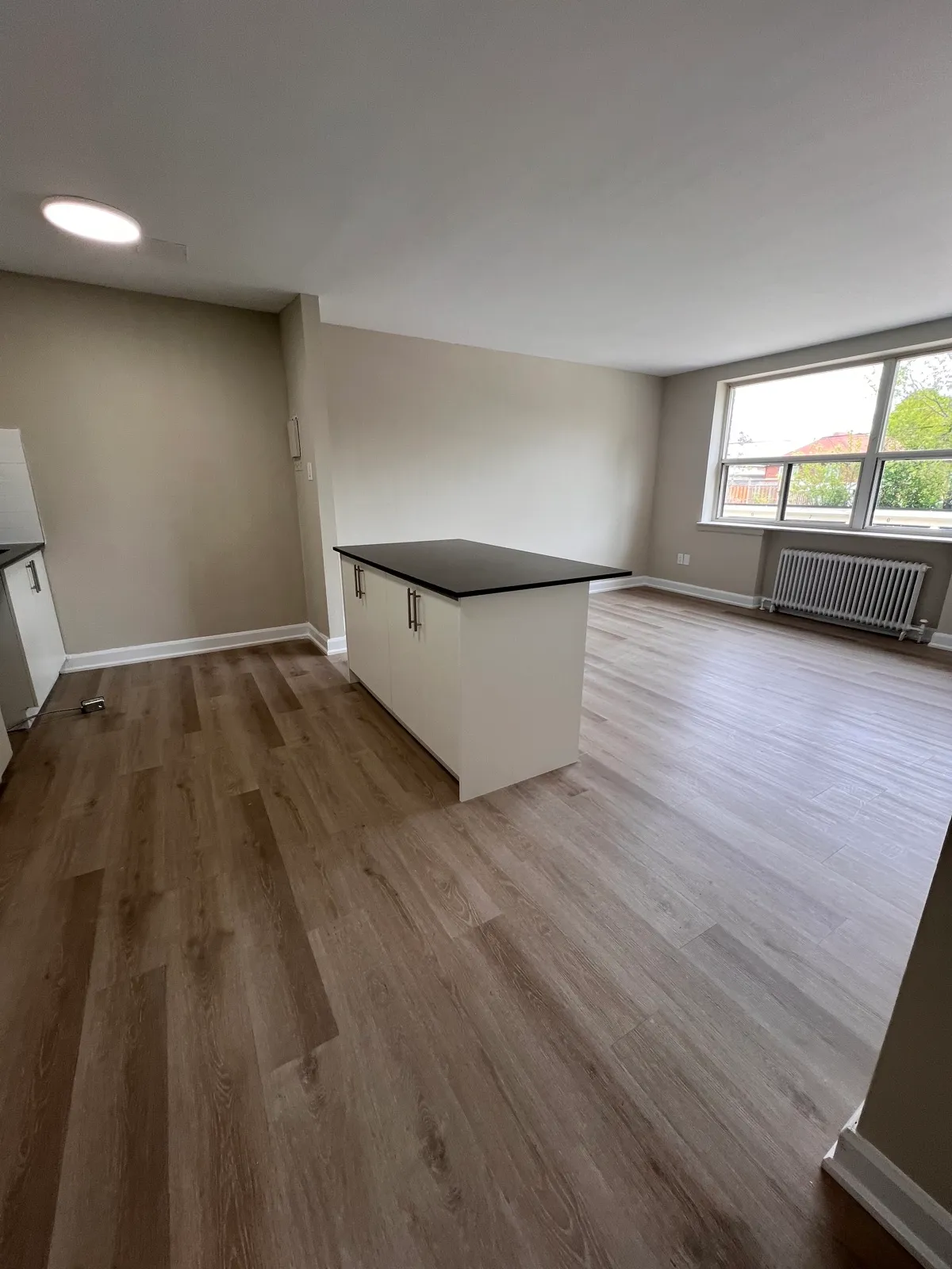 Kitchen island beside a finished living area and window