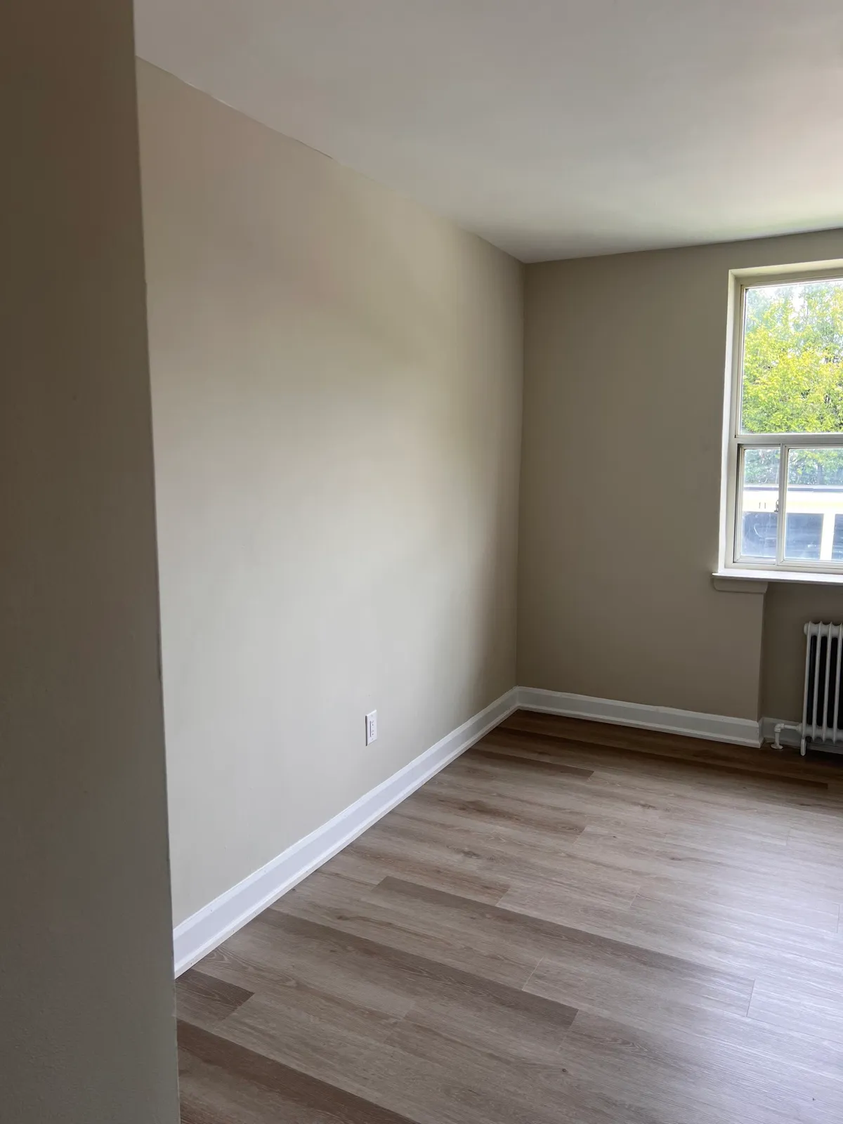 Finished room with new flooring, trim, and neutral walls