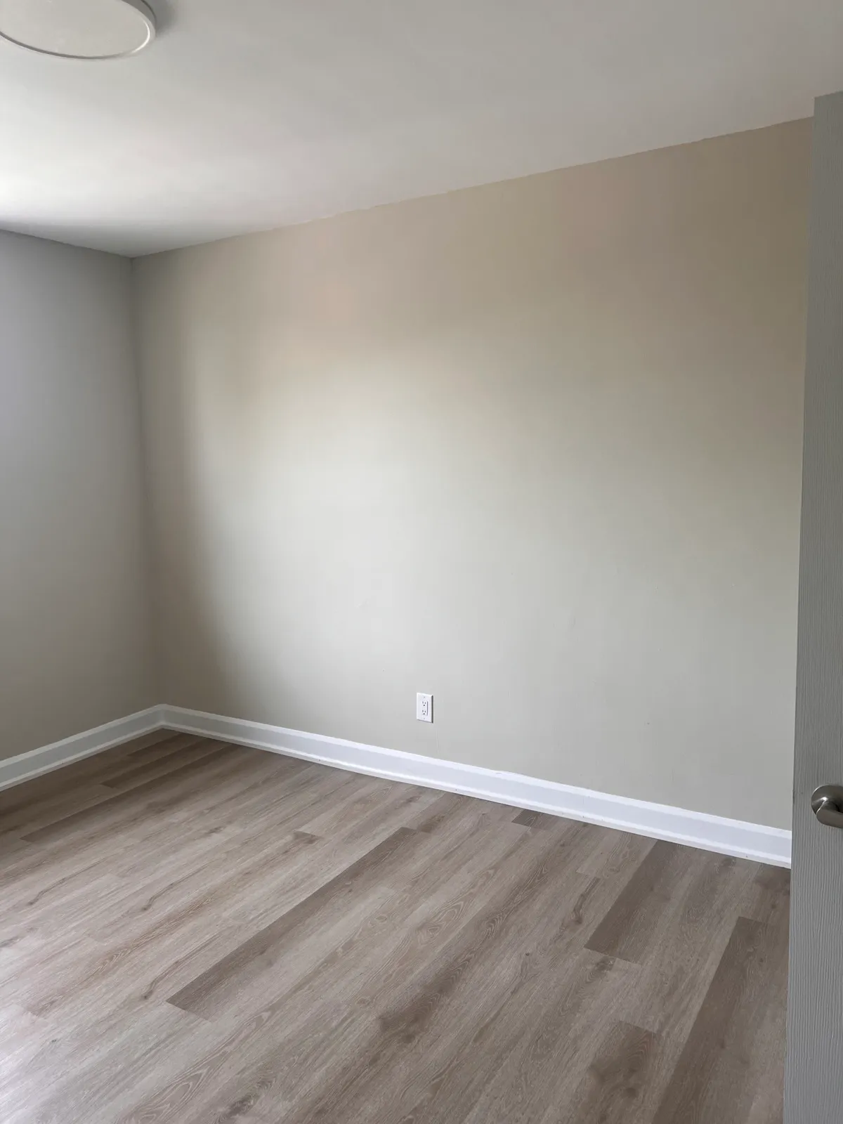 Finished room with fresh neutral walls, trim, and flooring