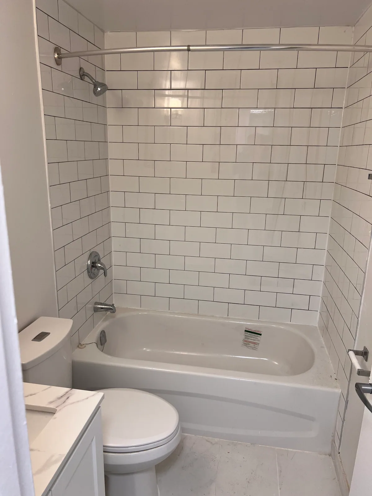 Completed bathtub and white subway-tile surround in the Goreway Brampton condo bathroom