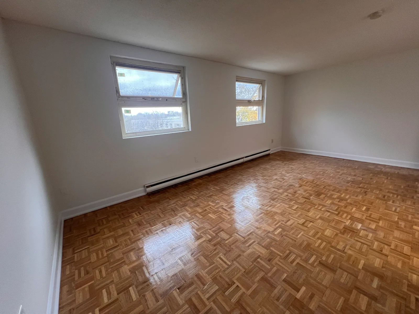 Completed Brampton condo living room with refreshed parquet flooring and light walls