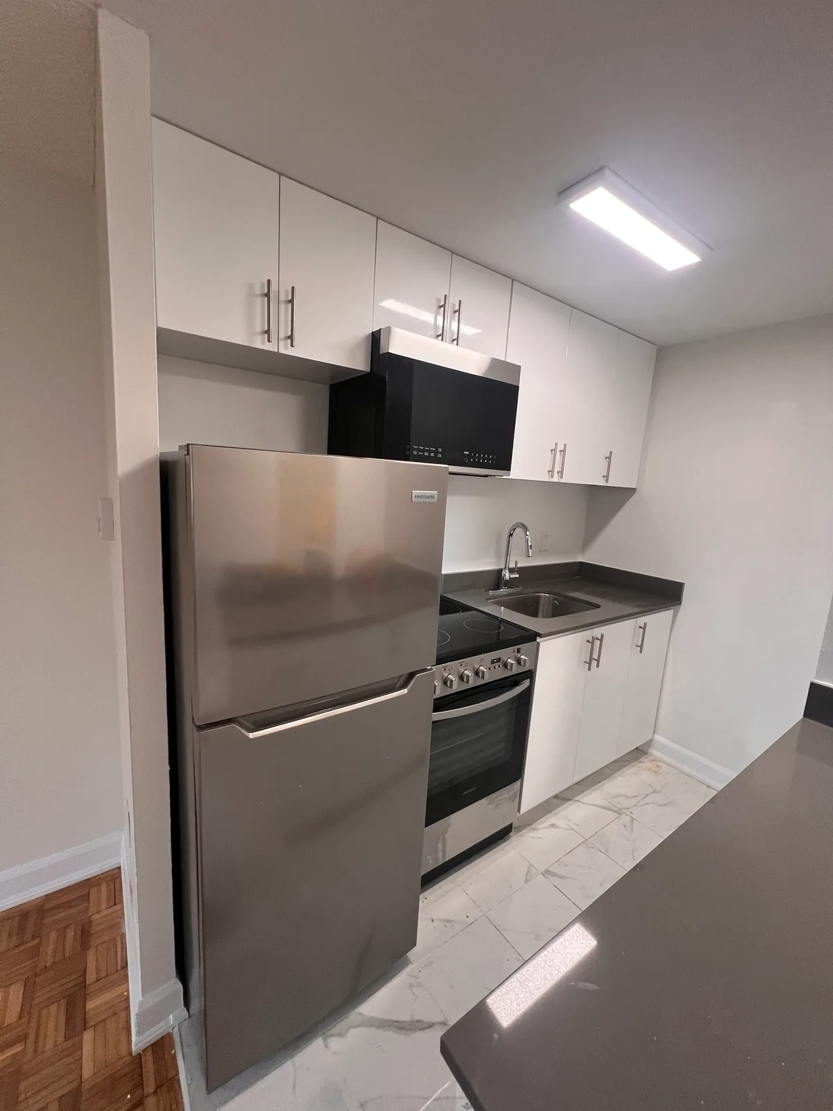 Completed gloss-white kitchen cabinets and stainless appliances at Goreway Brampton
