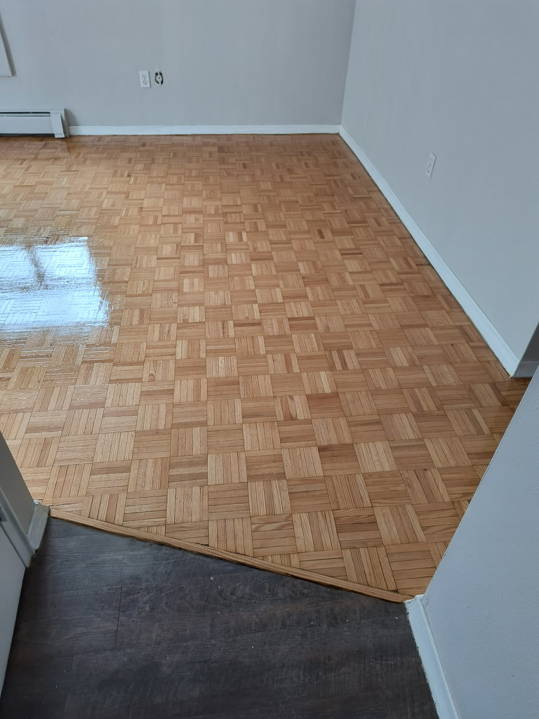 Hamilton parquet floor after sanding and finishing beside adjoining dark flooring