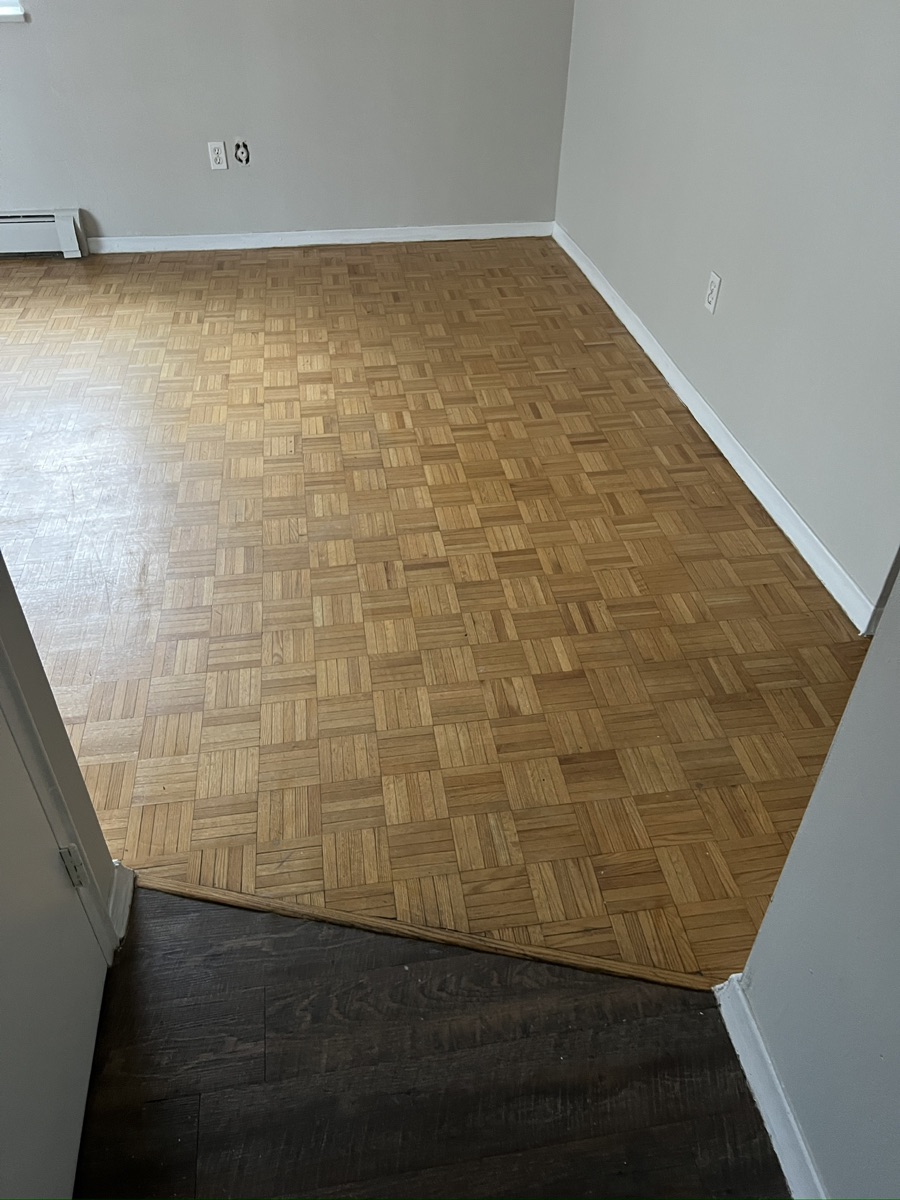 Worn parquet flooring before sanding and refinishing at a Hamilton residential interior