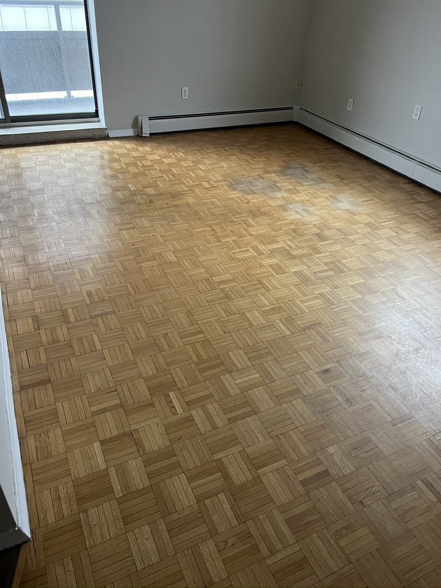 Wide view of worn parquet floor before refinishing in Hamilton Ontario