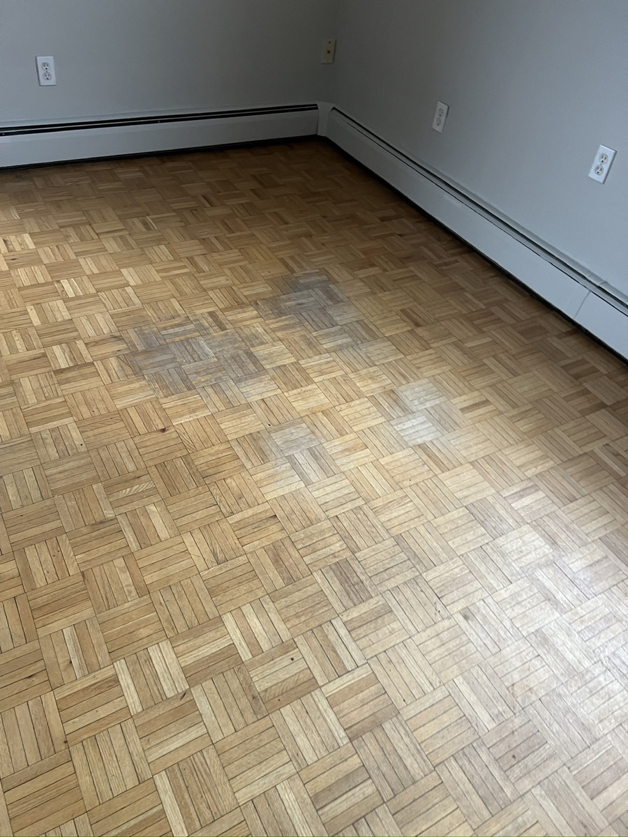 Dull parquet floor with worn finish before sanding in Hamilton