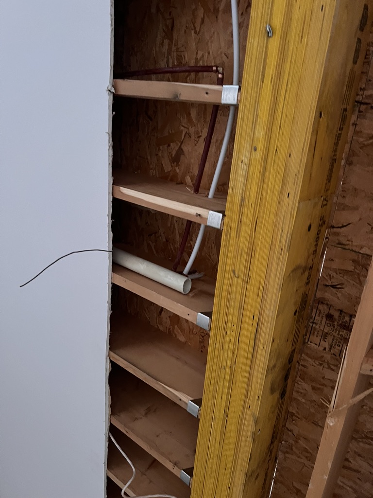Plumbing and electrical services exposed inside a wall cavity
